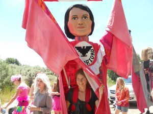 Rivera Sun carrying the giant Dolores Huerta puppet in Love-In-Action's Activists, Whistleblowers, and Muckrakers procession. Puppet built by Jeanne Green and Marilyn Hoff. Photo by Dariel Garner