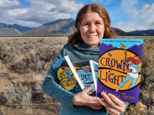 Author Rivera Sun holds up the latest book in her fantasy series, The Crown of Light.